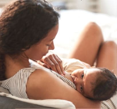 Mama geeft borstvoeding in bed aan baby
