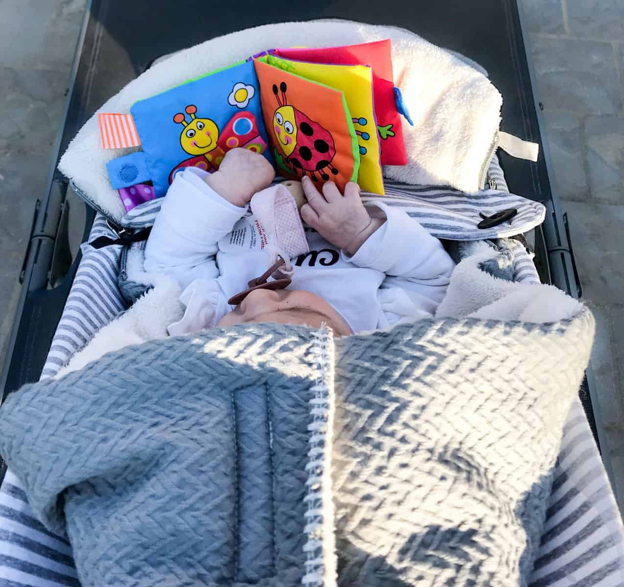 baby in de kinderwagen met een boek